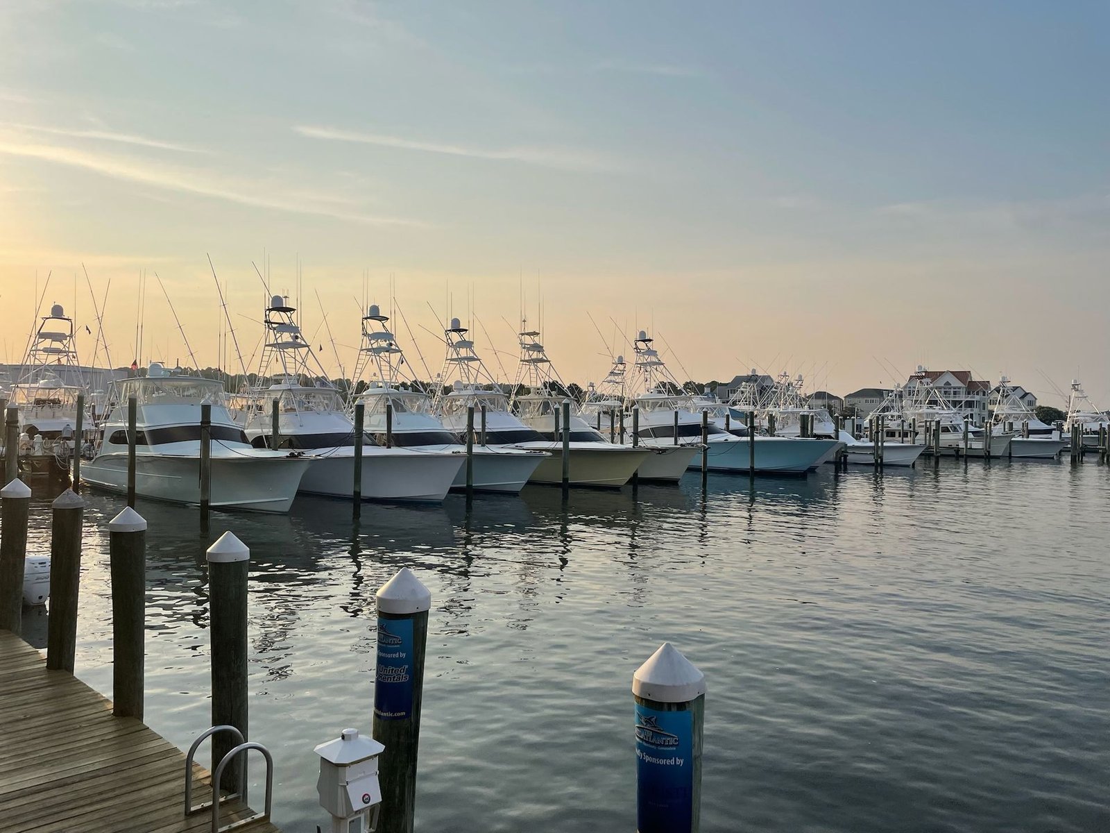 Empty marina slips at dusk under a wide sky